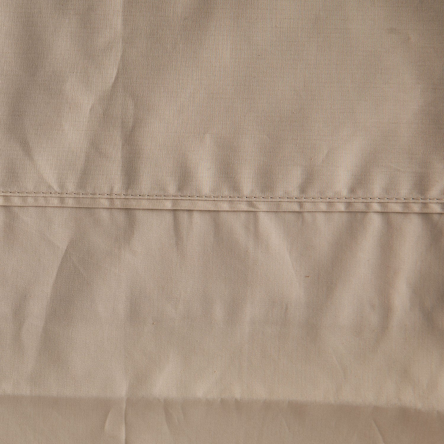 Close-up of beige fabric with a visible seam
