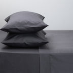 Gray bedding set with two pillows on a plain background