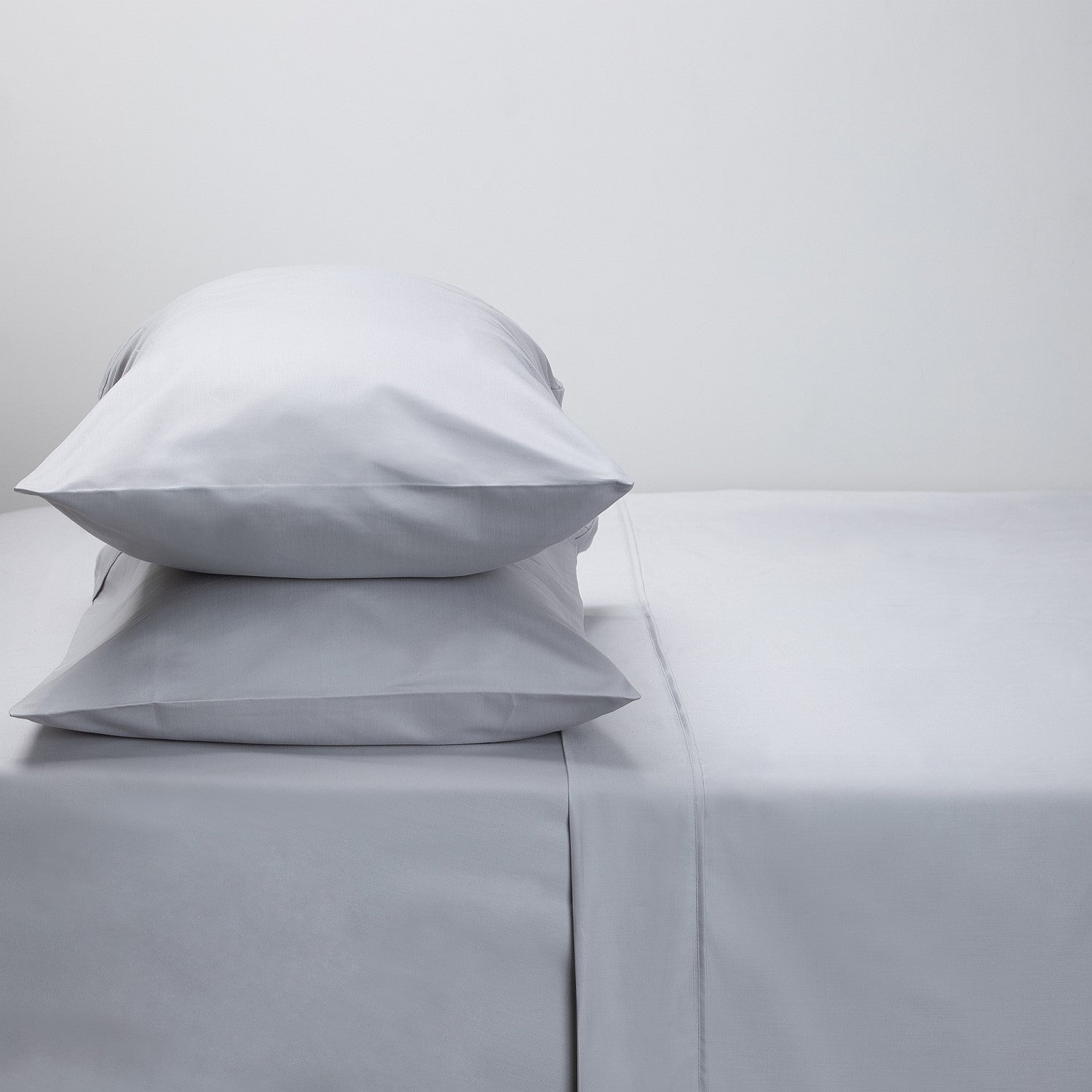 Gray bedding set with two pillows on a light gray background