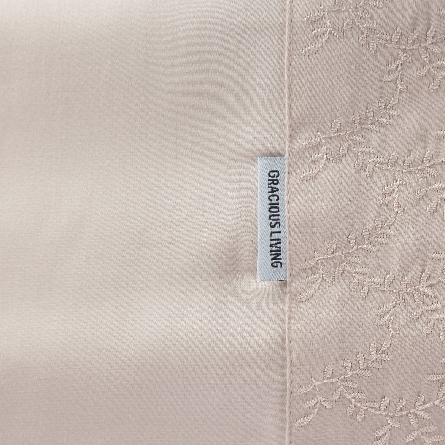 Close up of the Gracious Living Celine Embroidery Sheet Set in Pink, showing the embroidered leaf cuff and brand label.
