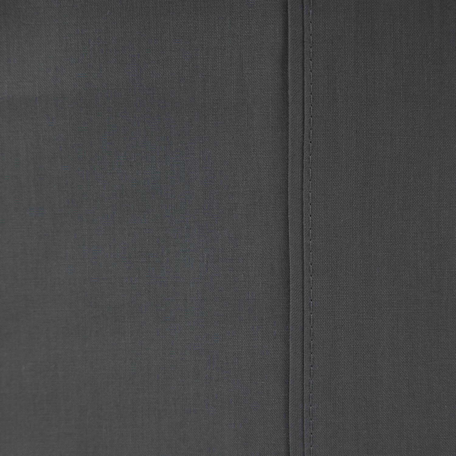 Close-up of the Home Co. Ella Cotton Sheet Set in Charcoal, showing the dark grey woven fabric and stitched seam detail.