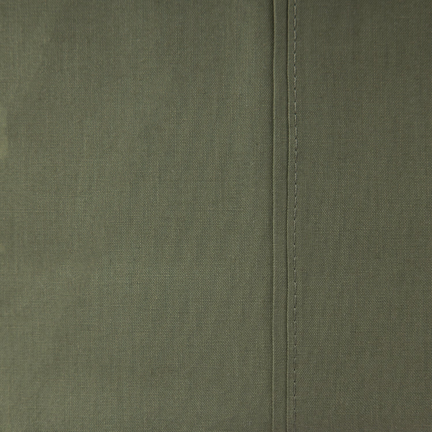Close-up of the Home Co. Ella Cotton Sheet Set in Olive, showing the muted green woven fabric and stitched seam detail.