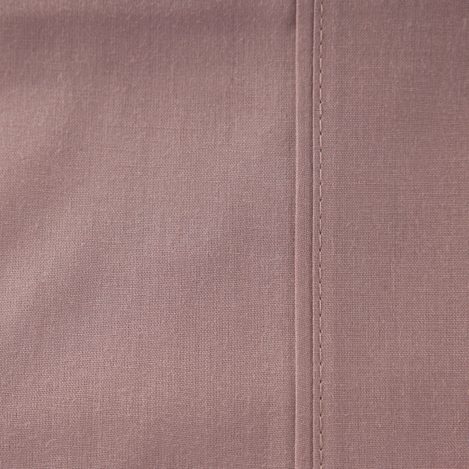 Close-up of the Home Co. Ella Cotton Sheet Set in Dusky Mauve, showing the smooth woven fabric and stitched seam detail.