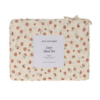 Close-up of the Pure & Simple Lucy Printed Sheet Set in Floral, featuring small rust-coloured flowers with green leaves on a warm cream background.