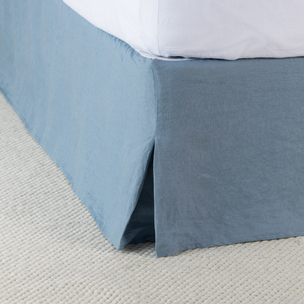 Denim 100% linen valance styled around the base of a bed, featuring a relaxed drape and split corner detail.