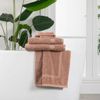 Textured towel range neatly styled over a freestanding bath tub in a modern bathroom setting.