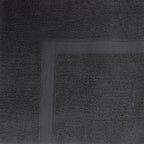 Close-up of a Coal  towel featuring a soft textured pile and classic border detailing.