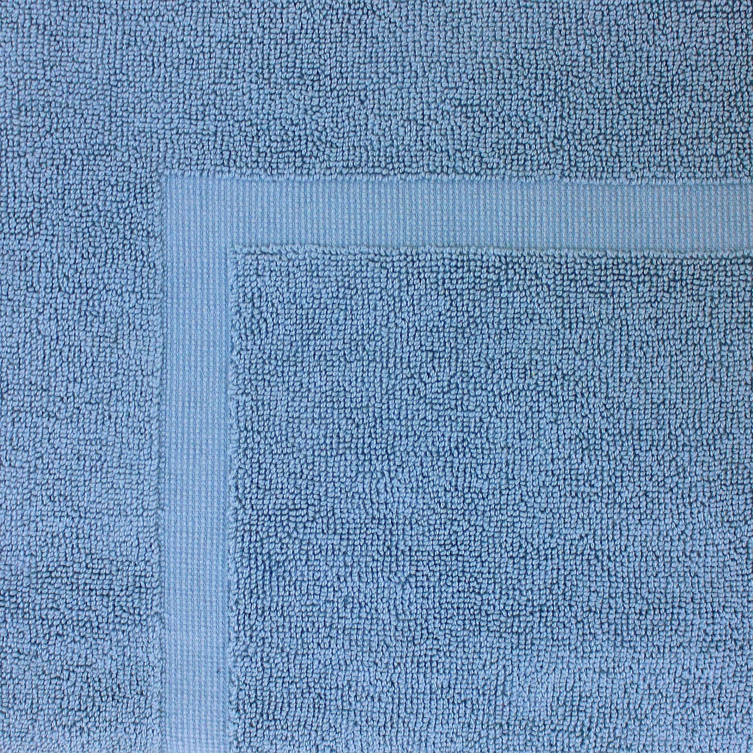 Close-up of a cornflower blue towel featuring a soft textured pile and classic border detailing.