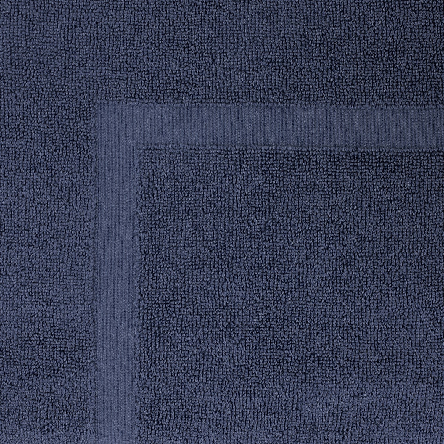 Close-up of a Ink Blue towel featuring a soft textured pile and classic border detailing.