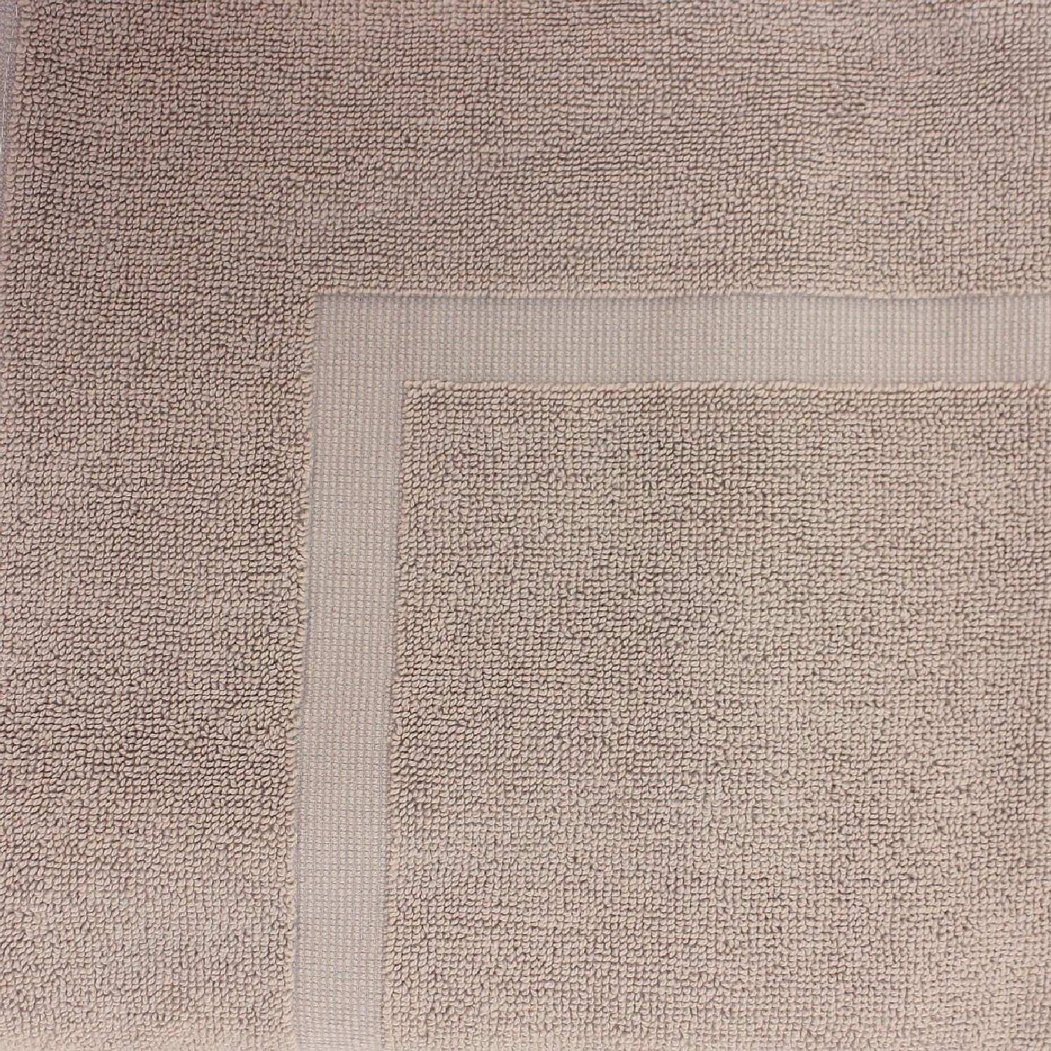Close-up of a Sand towel featuring a soft textured pile and classic border detailing.