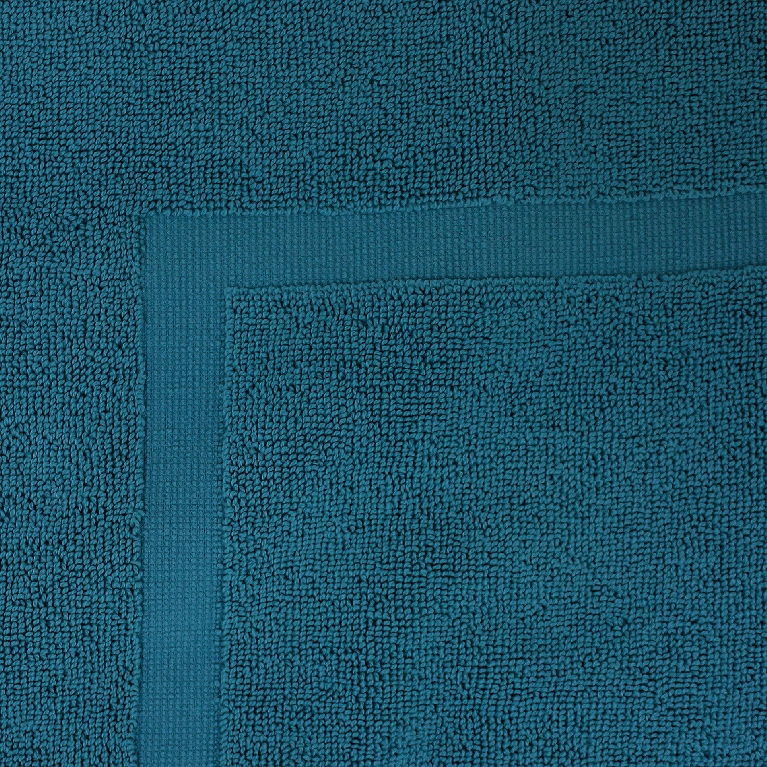Close-up of a Teal  towel featuring a soft textured pile and classic border detailing.