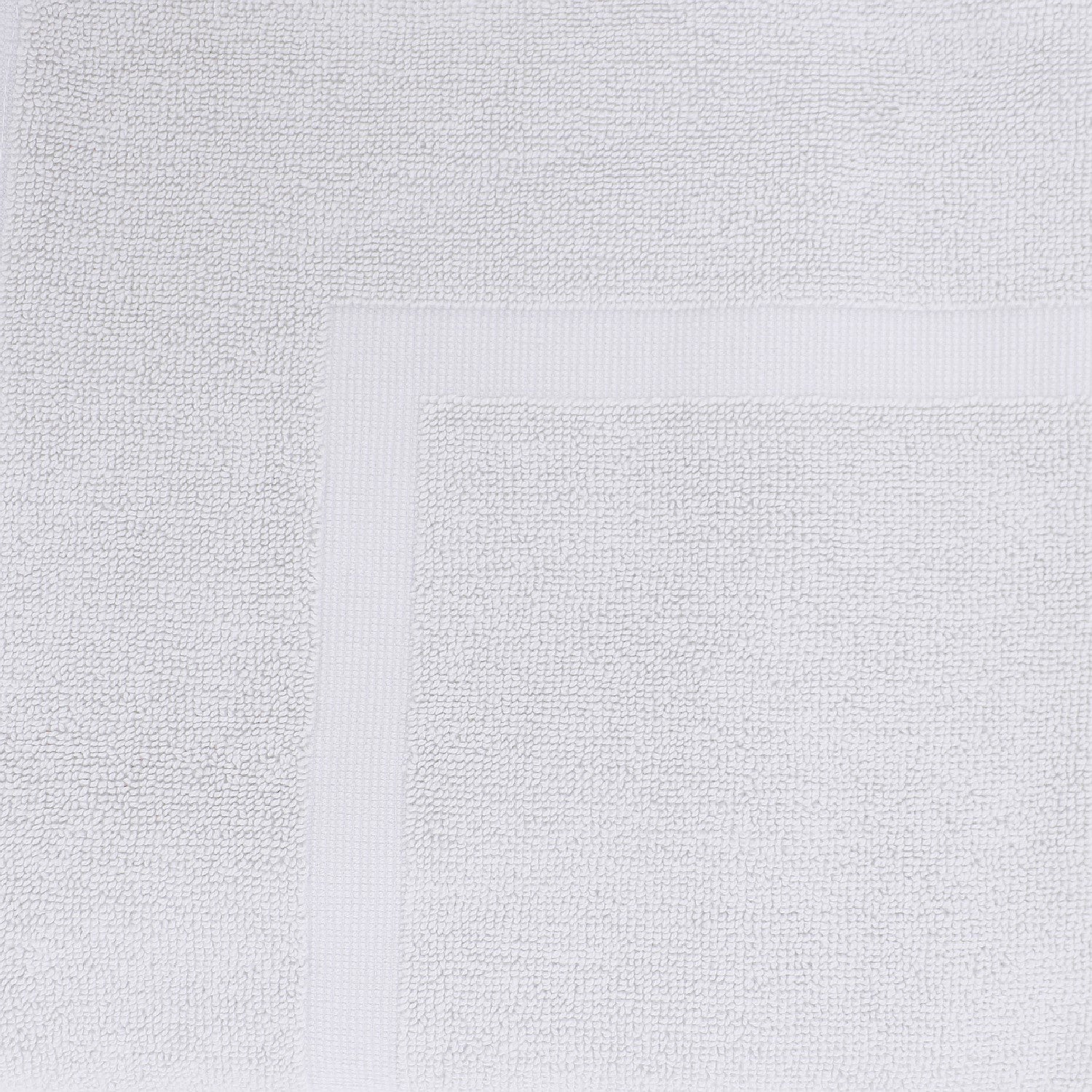 Close-up of a White towel featuring a soft textured pile and classic border detailing.