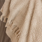 Close-up detail of the Home Co. Mateo Throw in Natural, featuring a richly textured woven design with decorative tassel fringe.