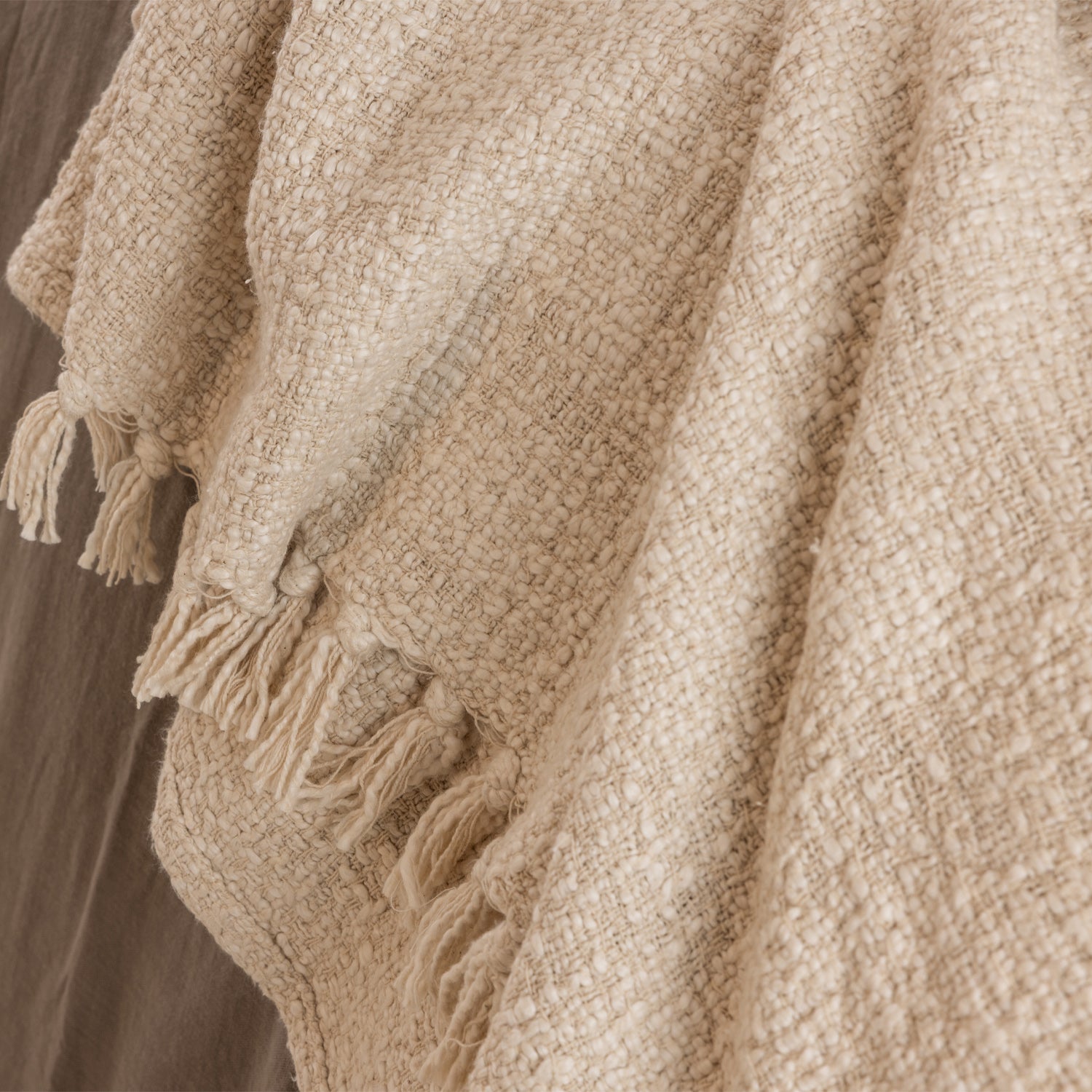 Close-up detail of the Home Co. Mateo Throw in Natural, featuring a richly textured woven design with decorative tassel fringe.