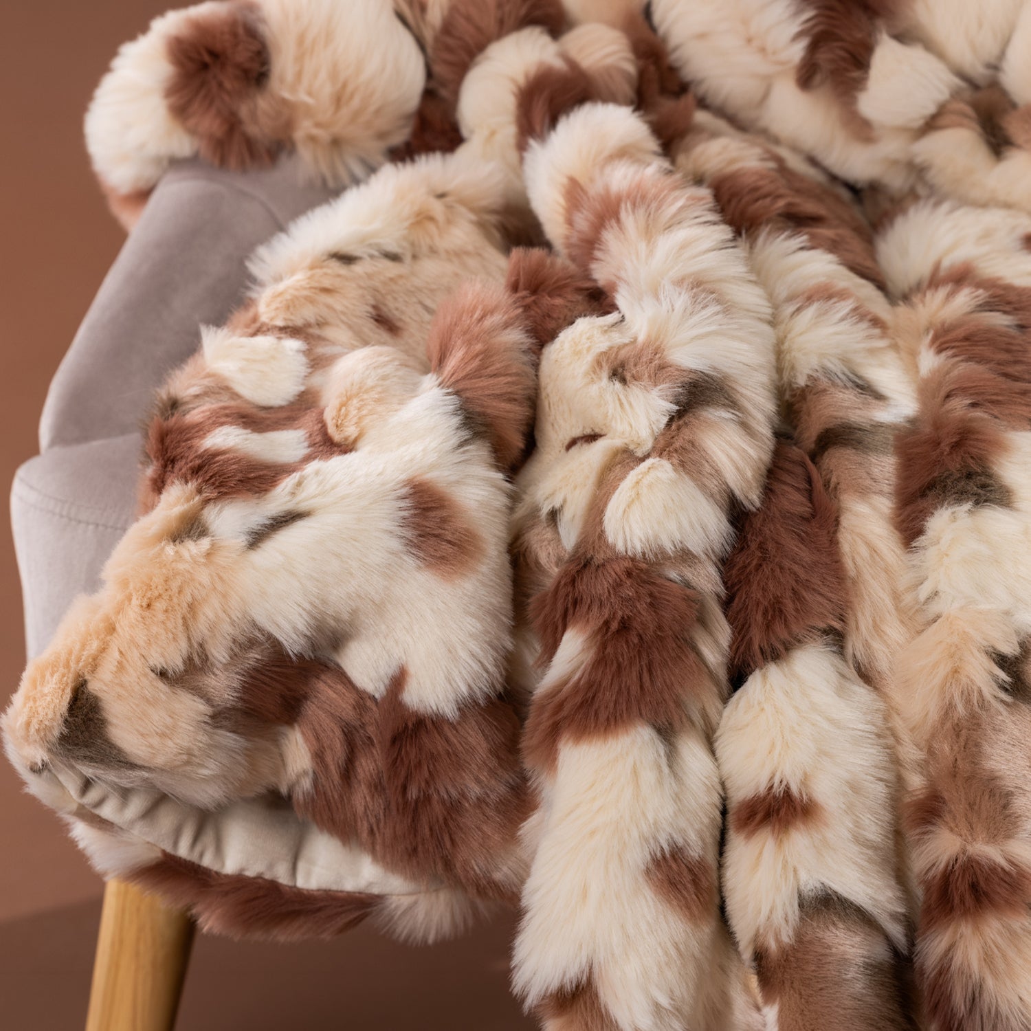 Close-up of the Amparo Macey Throw in blush, showing the fluffy faux fur texture and warm spotted pattern.