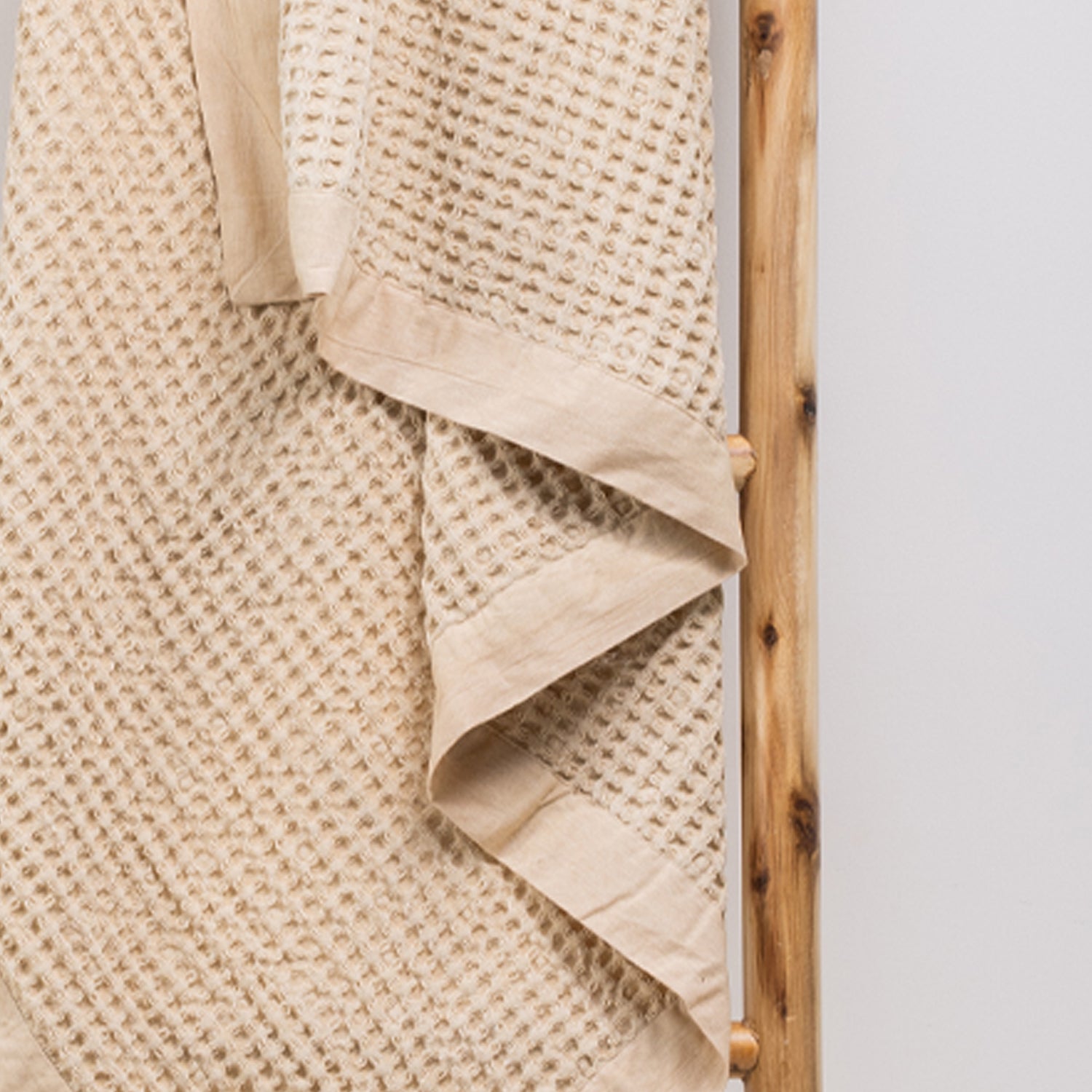 A close-up of the cotton waffle throw highlights its richly textured weave and classic woven border, adding timeless style and inviting texture to any space.