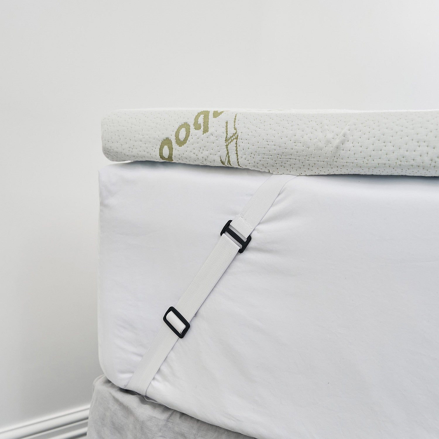 Close up of the bambou mattress topper attached to the ed with elastic straps 