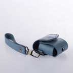 Blue leather key holder with strap on a light gray background
