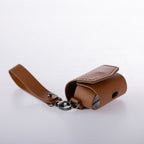 Brown leather keychain with a strap on a light gray background