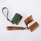 Green and brown leather cases with lanyards on a white background