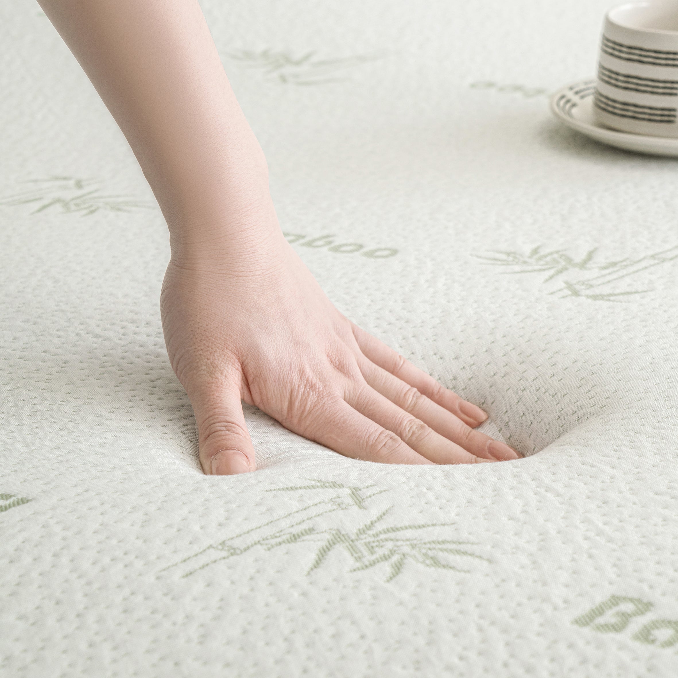 Hand pressing into the surface of the Bambou Memory Foam Mattress Topper, demonstrating the responsive contouring support and pressure-relieving memory foam.