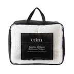 Eden Bobble Mattress Topper 800gsm in white storage bag with black trim and handles.