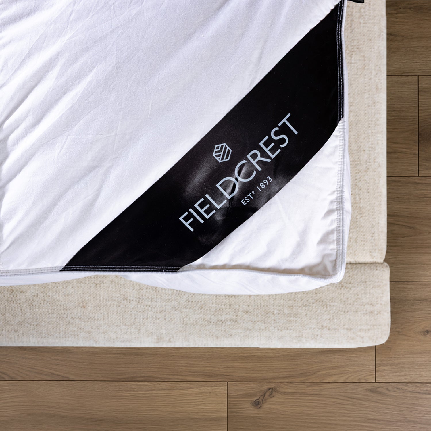 Fieldcrest duck feather and down dual layer mattress topper fitted on a mattress with elastic straps.