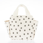 Cream corduroy lunch tote with brown daisy print, carry handles, and side pockets on a white background.