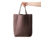 Design Plus Quinn Quilted Travel Tote in Chocolate, featuring a soft padded design with horizontal quilted stitching and long carry handles.