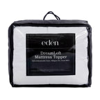 A packaged white mattress topper in a clear zippered storage bag with a black handle and a large black front label reading 'eden DreamLoft Mattress Topper'.