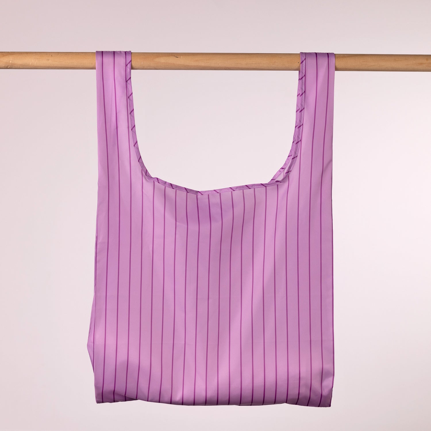 Home Co. Recycled Bottle Foldable Bag Stripe Lavender shown open and hanging on a wooden rail.