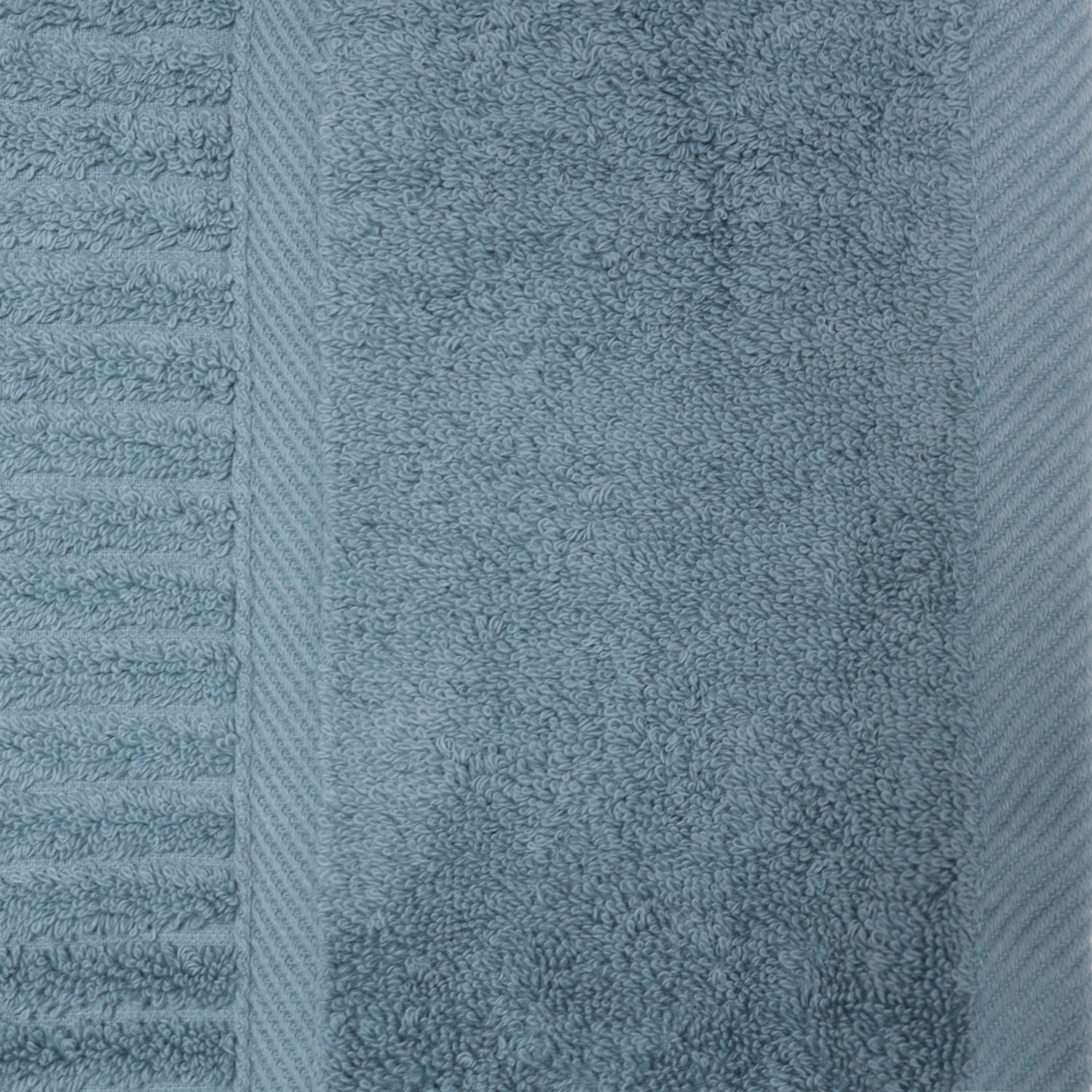 Close-up of the denim Design Plus Ivy towel showing the plush cotton texture, ribbed detailing and woven border.