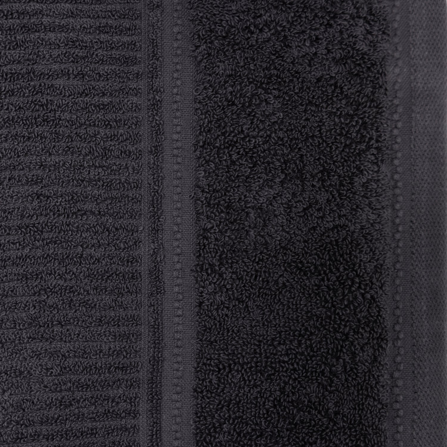 Close-up of the charcoal Design Plus Tia towel, showing the dense cotton loops and decorative border.