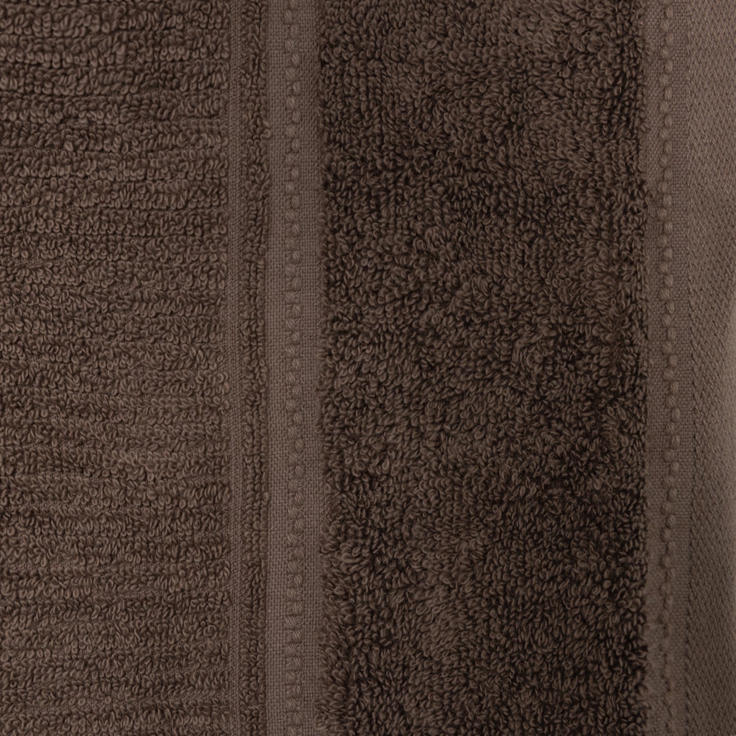 Close-up of the chocolate Design Plus Tia towel, highlighting the plush cotton texture and woven border.