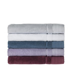 Stack of folded Design Republique Elani bath sheets in Silver, White, Ocean, Lavender and Mulberry, displayed on a white background.
