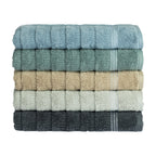 Stack of Home Co. Penny Self Stripe towels in blue, seafoam, natural, pale green and charcoal, showing the textured stripe design and decorative border detail.