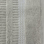 Close-up of the Home Co. Penny Self Stripe Face Cloth in silver, showing the soft textured cotton loops, raised stripe pattern and decorative border detail.