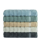 Stack of Home Co. Penny Self Stripe towels in blue, seafoam, natural, pale green and charcoal, showing the textured stripe design and decorative border detail.