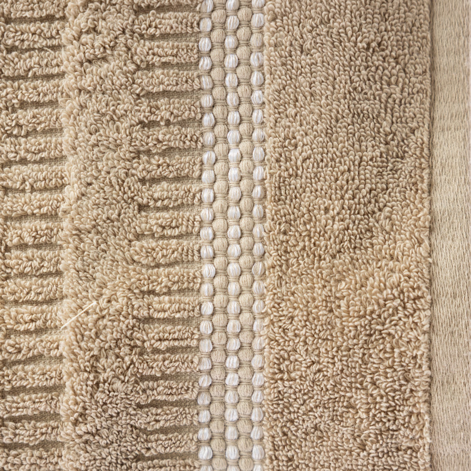 Close-up of the Home Co. Penny Self Stripe Face Cloth in taupe, showing the soft textured cotton loops, raised stripe pattern and decorative border detail.