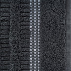 Close-up of the Home Co. Penny Self Stripe Face Cloth in coal, showing the soft textured cotton loops, raised stripe pattern and decorative border detail.