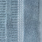 Close-up of the Home Co. Penny Self Stripe Face Cloth in dusty blue, showing the soft textured cotton loops, raised stripe pattern and decorative border detail.