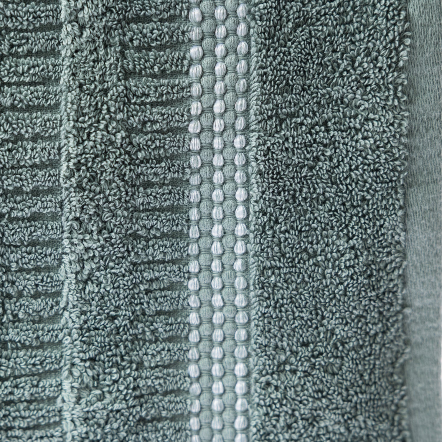 Close-up of the Home Co. Penny Self Stripe Face Cloth in seafoam, showing the soft textured cotton loops, raised stripe pattern and decorative border detail.