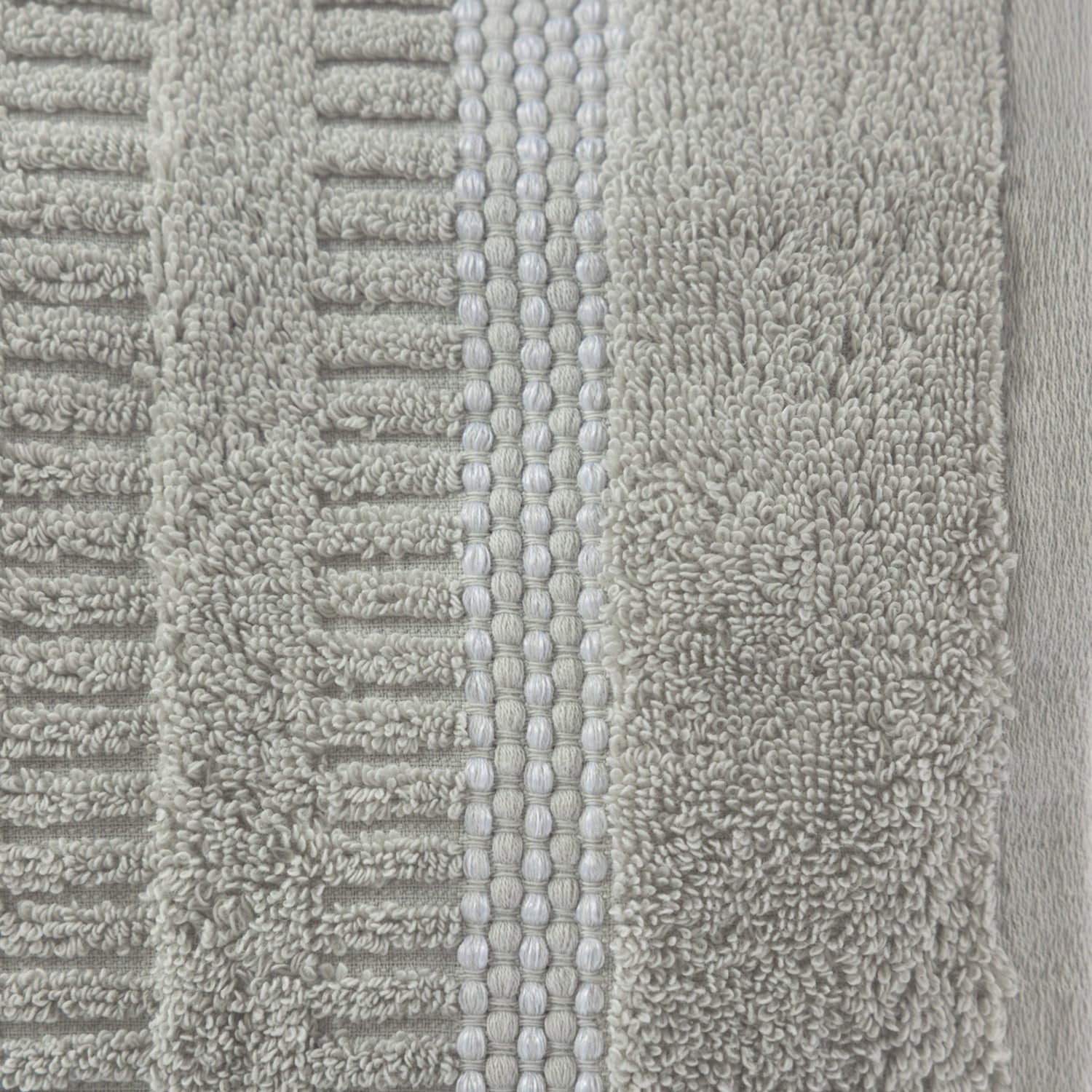 Close-up of the Home Co. Penny Self Stripe Face Cloth in silver, showing the soft textured cotton loops, raised stripe pattern and decorative border detail.