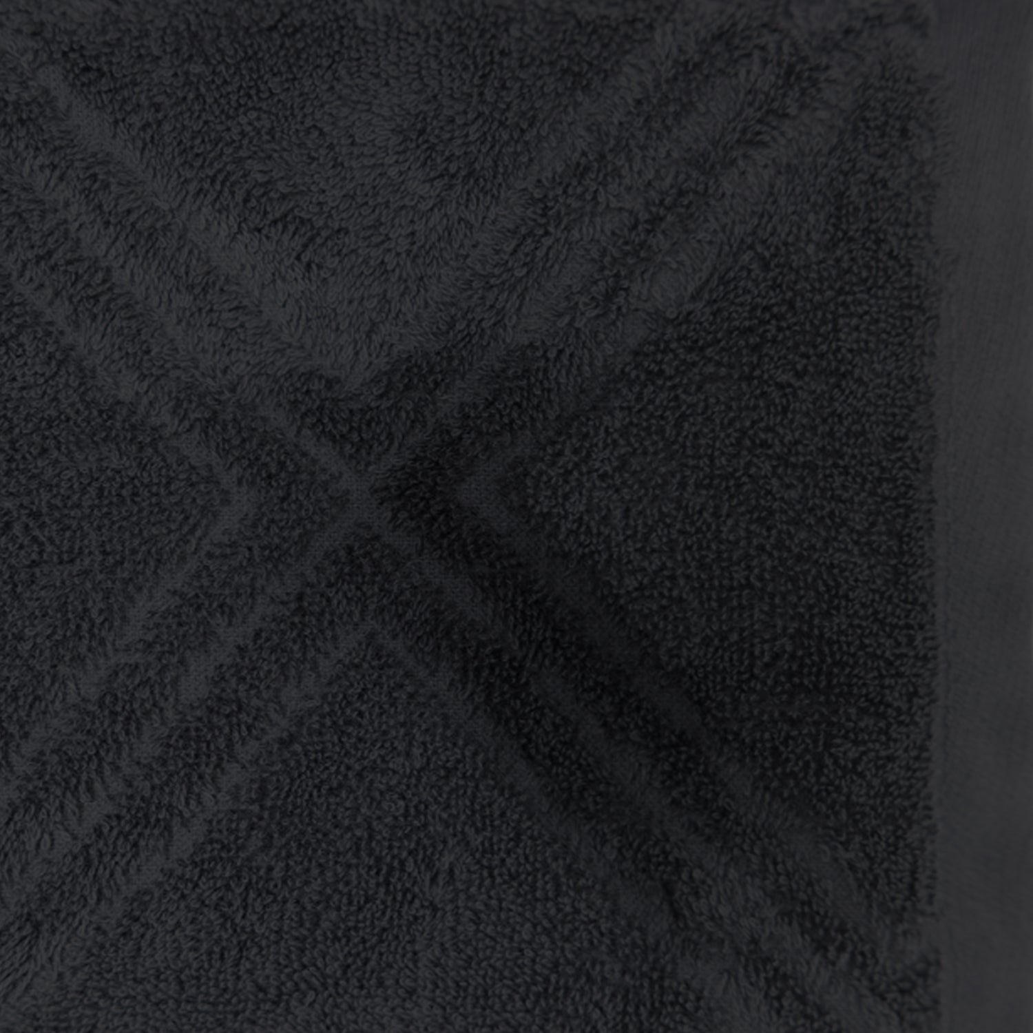 Close-up of the Design Republique Gemma Plush 550gsm bath towel in charcoal, featuring a raised geometric terry pattern and smooth border.