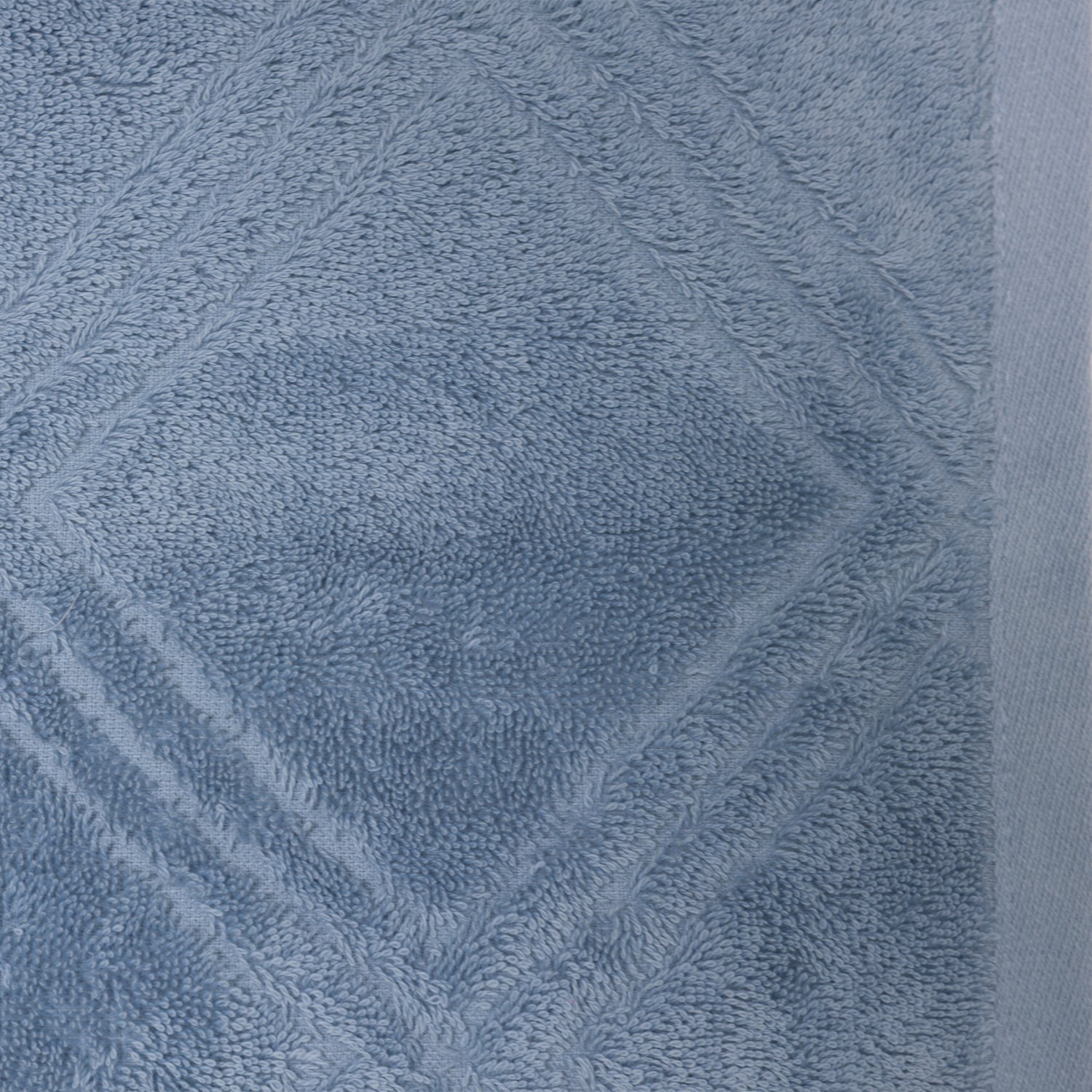 Close-up of the Design Republique Gemma Plush 550gsm hand towel in faded blue, featuring a plush raised geometric pattern.