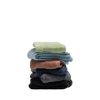 Stack of six Fieldcrest Amelie plush hand towels in French pear, sky blue, brick, navy, smoke and black, featuring soft cotton texture and ribbed border detailing.
