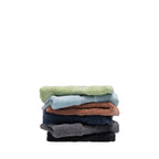 Stack of six Fieldcrest Amelie plush face cloths in French pear, sky blue, brick, navy, smoke and black, featuring soft cotton texture and ribbed border detailing.