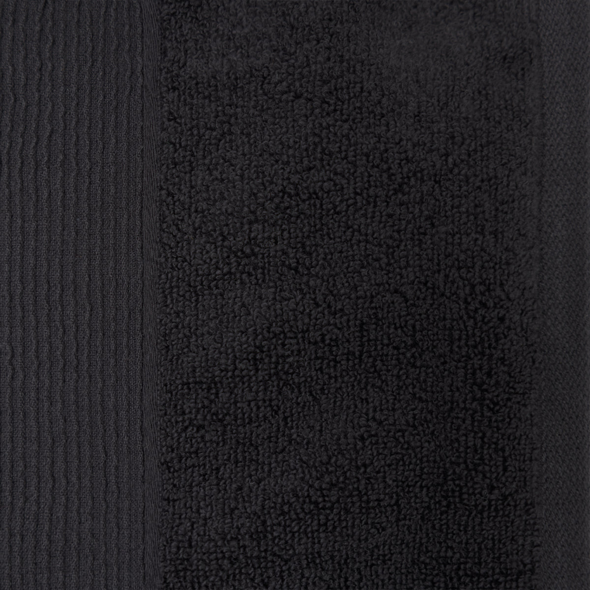 Close-up of a black plush face cloth showing the soft looped cotton texture and ribbed border detailing.