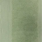 Close-up of a French pear green plush face cloth showing the soft looped texture and ribbed border.