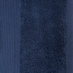 Close-up of a navy plush face cloth showing the dense cotton texture and ribbed border detailing.